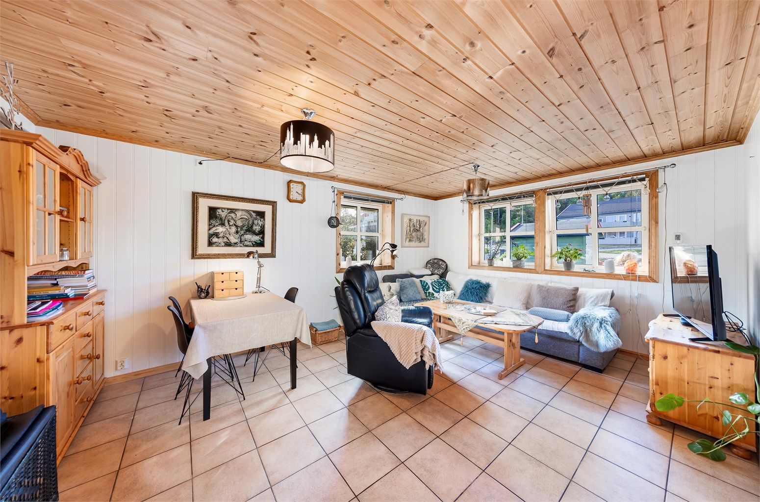 Stuen i utleiedelen har flislagt gulv med vannbåren varme og åpen løsning mot kjøkkenet.