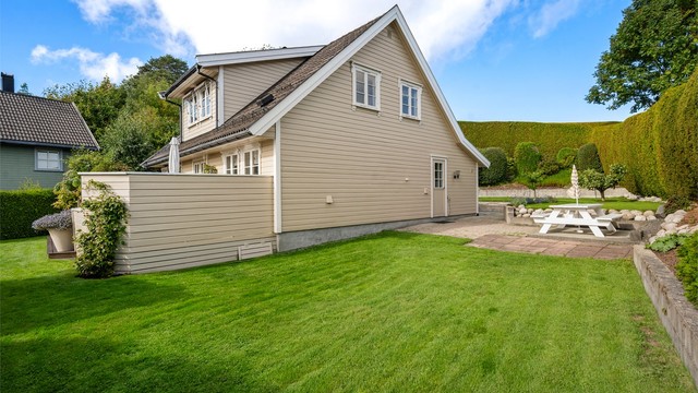 Eiendommen fremstår velstelt med vakre beplantninger og flere opparbeidede uteplasser.