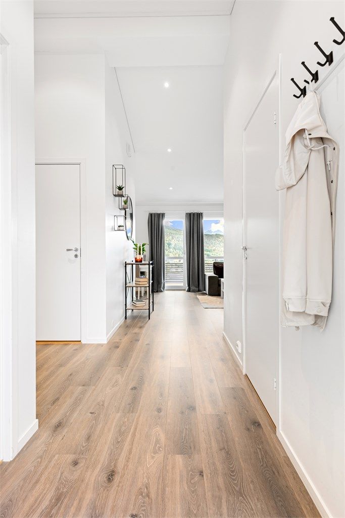 Gjennomgående laminatgulv og vannbåren gulvvarme skaper en lun og behagelig atmosfære fra entréen og videre inn i stuen.