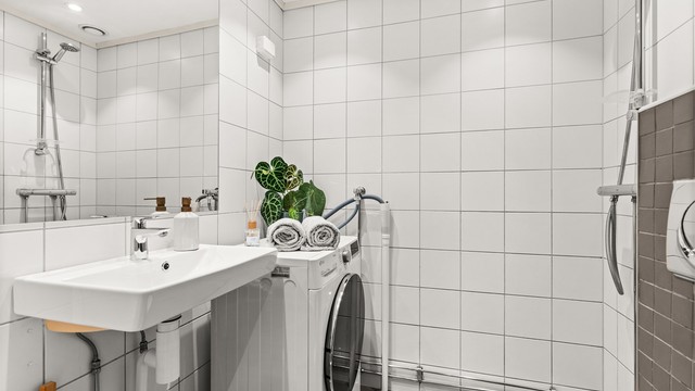 Flislagt bad med gulvvarme og opplegg for vaskemaskin. Badet ble rehabilitert i regi av borettslaget.