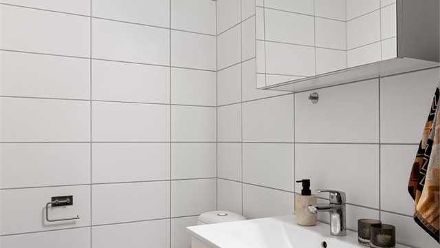 Badet er innredet med vegghengt servantinnredning, speilskap med overlys og stikkontakt samt gulvstående toalett