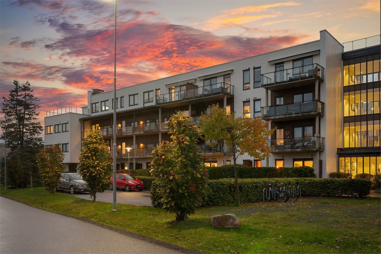 Opparbeidede uteområder rundt bygget med grøntarealer og sykkelparkering.