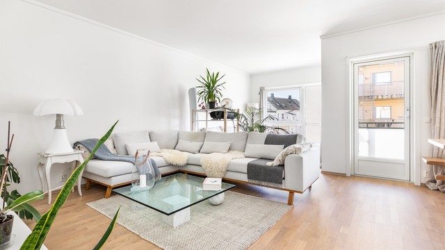 Store vinduer og høyden av tredje etasje fremmer gode lysforhold i stuen dagen gjennom.