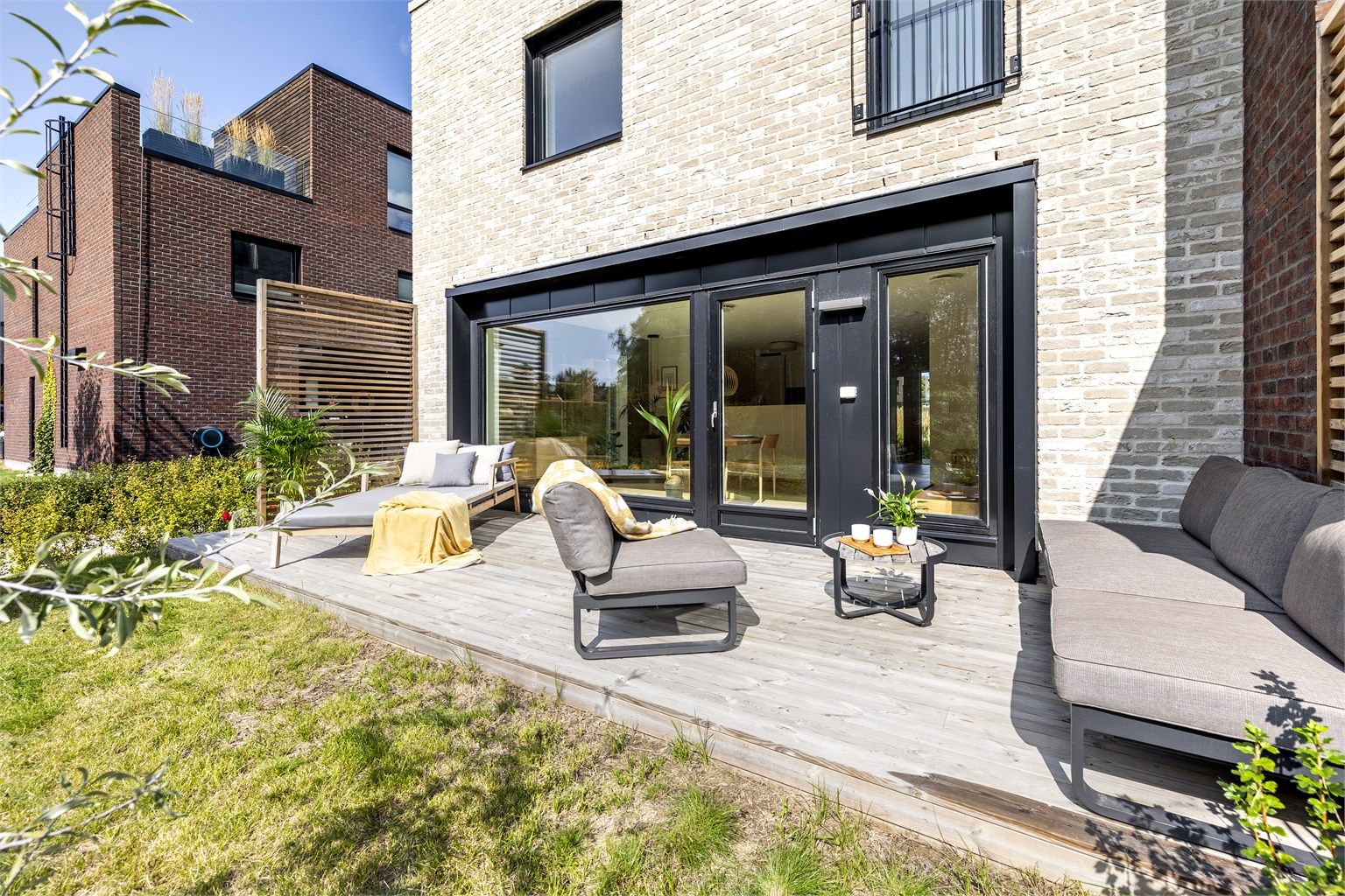 Theodor Hansens vei 7A - Boligen disponerer ca 180 kvm pent opparbeidet tomt rundt tre sider av boligen. Solrik markterrasse på ca 18 kvm samt hage i forlengelsen og plen langs bygget og på fremsiden. Foto: Martin Johnson (Sommerbilder) og Oh Shots