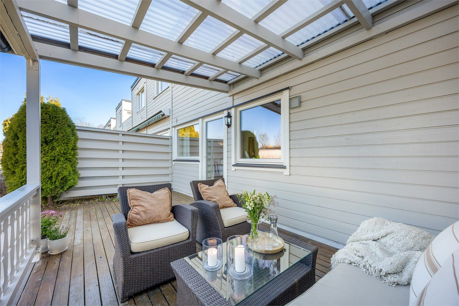 Den overbygde terrassen utvider utendørssesongen og gir en lun uteplass med direkte utgang fra stuen.