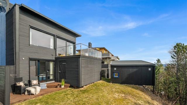 Boligens moderne fasade og arkitektoniske uttrykk gir et stilrent og helhetlig inntrykk, samtidig som utearealene er godt utnyttet. Boligen disponerer to uteboder på til sammen 9 kvm.