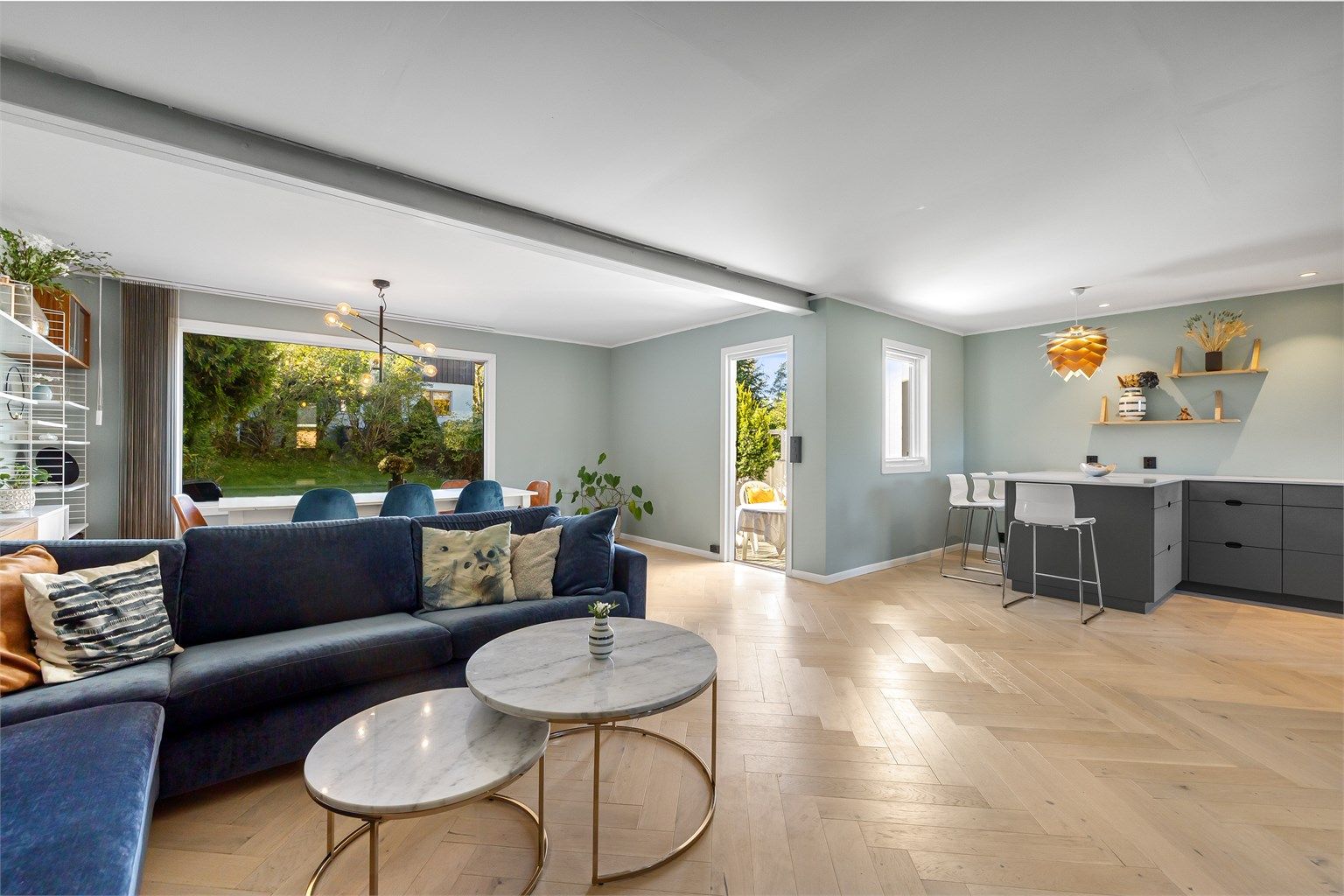 Boligens hjerte består av en lys og åpen stue med store vindusflater som gir rikelig dagslys og utsyn mot den private hagen. Megler: Anne Aartun/Krogsveen. Foto Bjørnar Solberg/Isnitt og Trond Walsø.