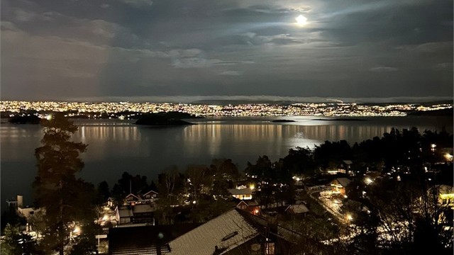 Selgers foto: Nyt synet av et opplyst Oslo mens fjorden glitrer i kveldsmørket.