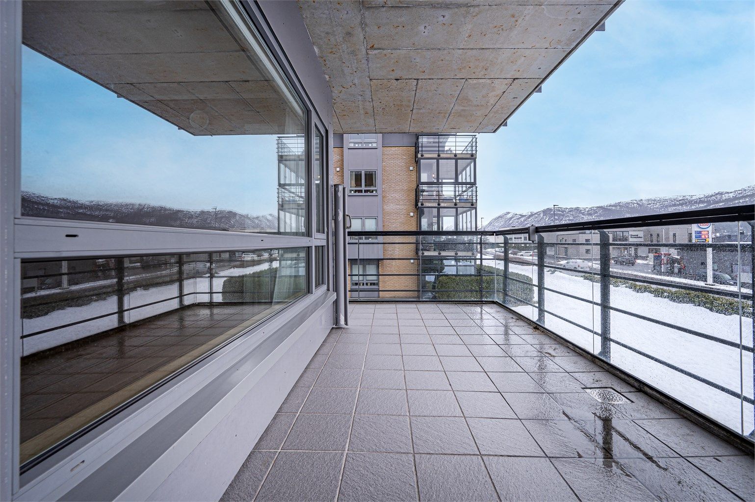 Fra stuen er det direkte utgang til en stor terrasse på 14 m² med rekkverk av stål og glass