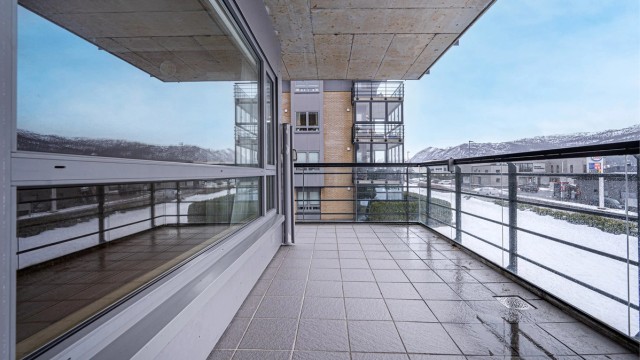 Fra stuen er det direkte utgang til en stor terrasse på 14 m² med rekkverk av stål og glass