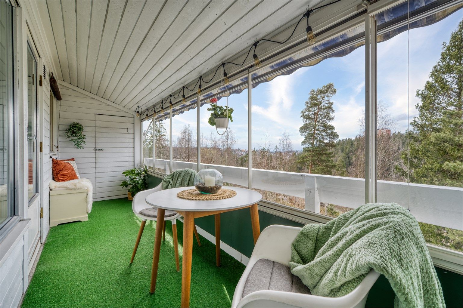 Den innglassede verandaen fungerer som et ekstra oppholdsrom store deler av året, med plass til en hyggelig sittegruppe.