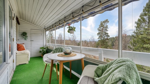 Den innglassede verandaen fungerer som et ekstra oppholdsrom store deler av året, med plass til en hyggelig sittegruppe.