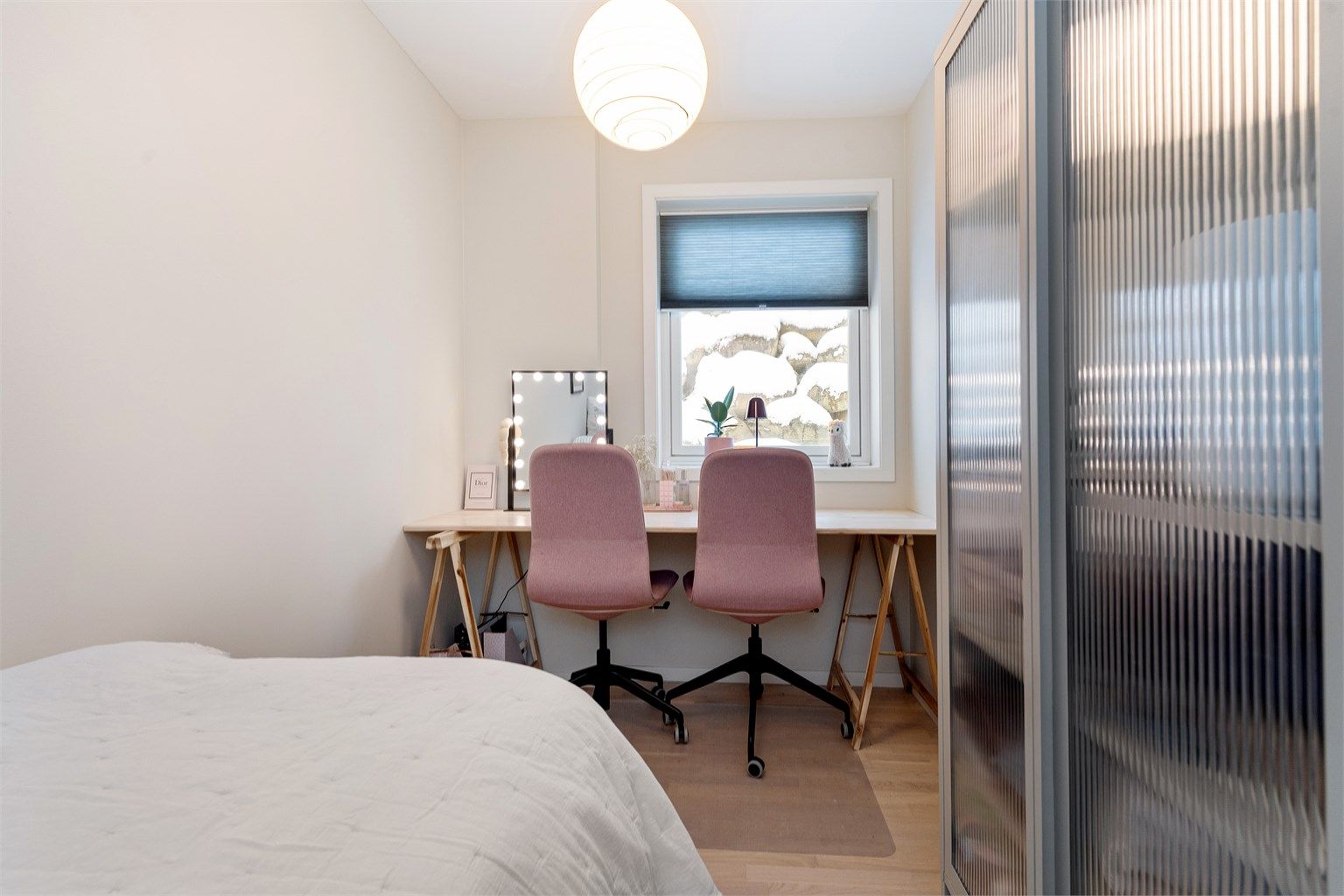 Boligens tredje soverom ligger i første etasje, med parkett på gulvet.