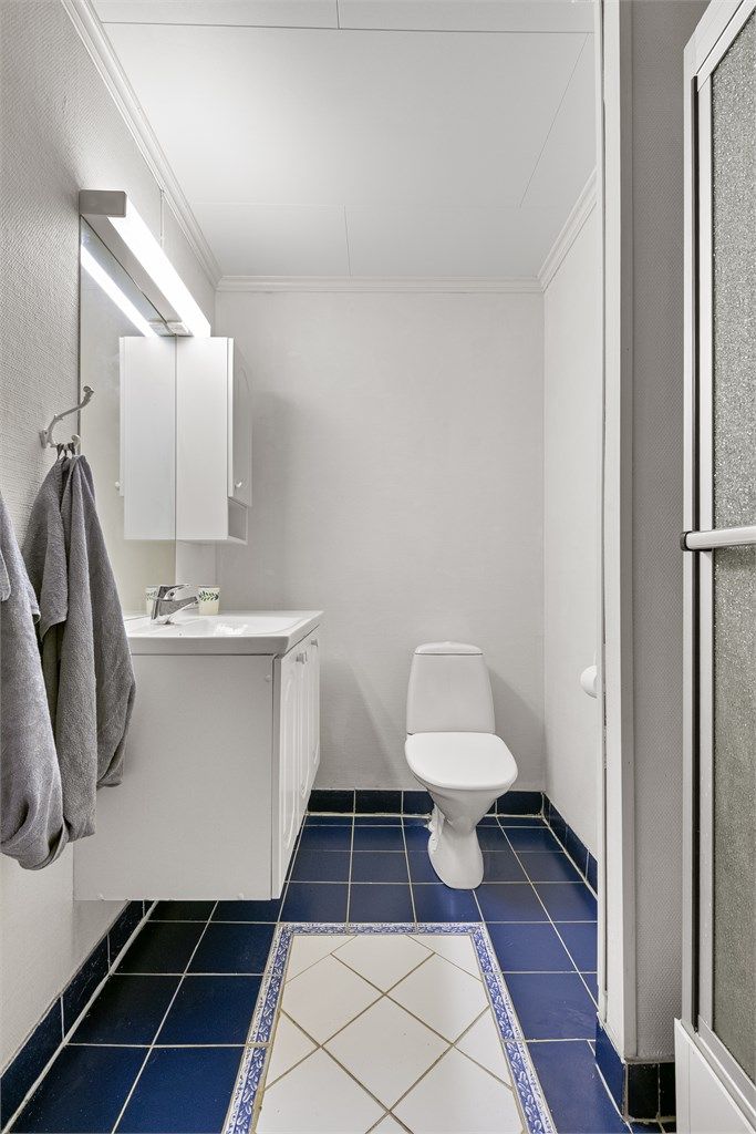 Badet har gulvvarme og servant med oppbevaring.