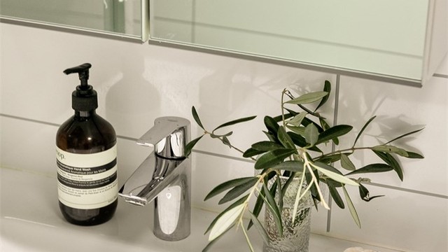 Rommet er innredet med servant med underskap og speilskap med belysning.