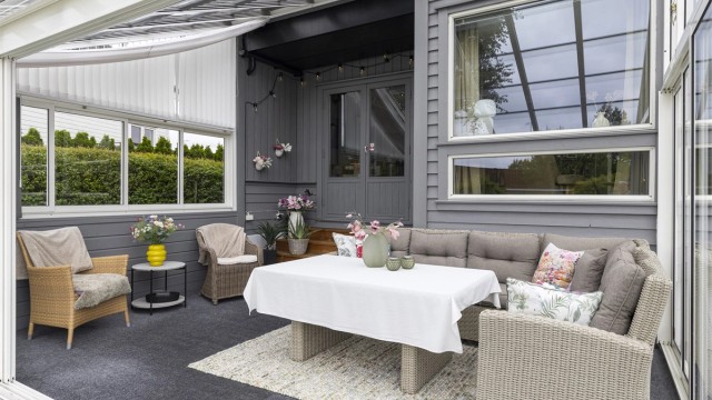 Den innglassede hagestuen har innlagt strøm og solskjermingsgardiner.