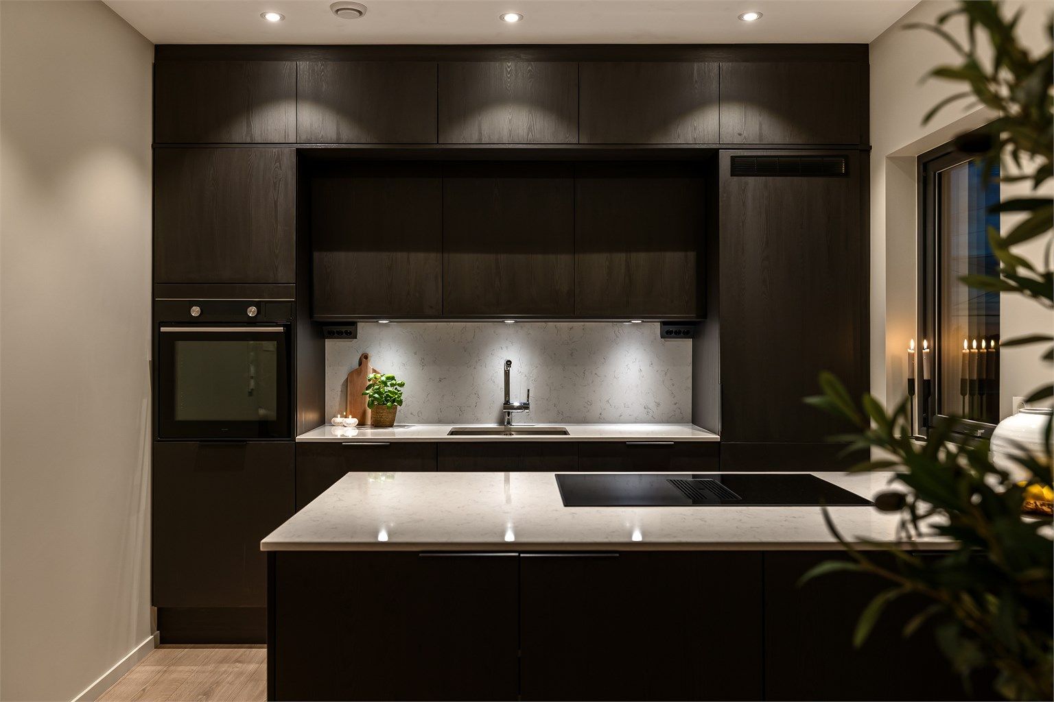 Kjøkkenet fremstår eksklusivt med mørke fronter, og lys stein benkeplate.