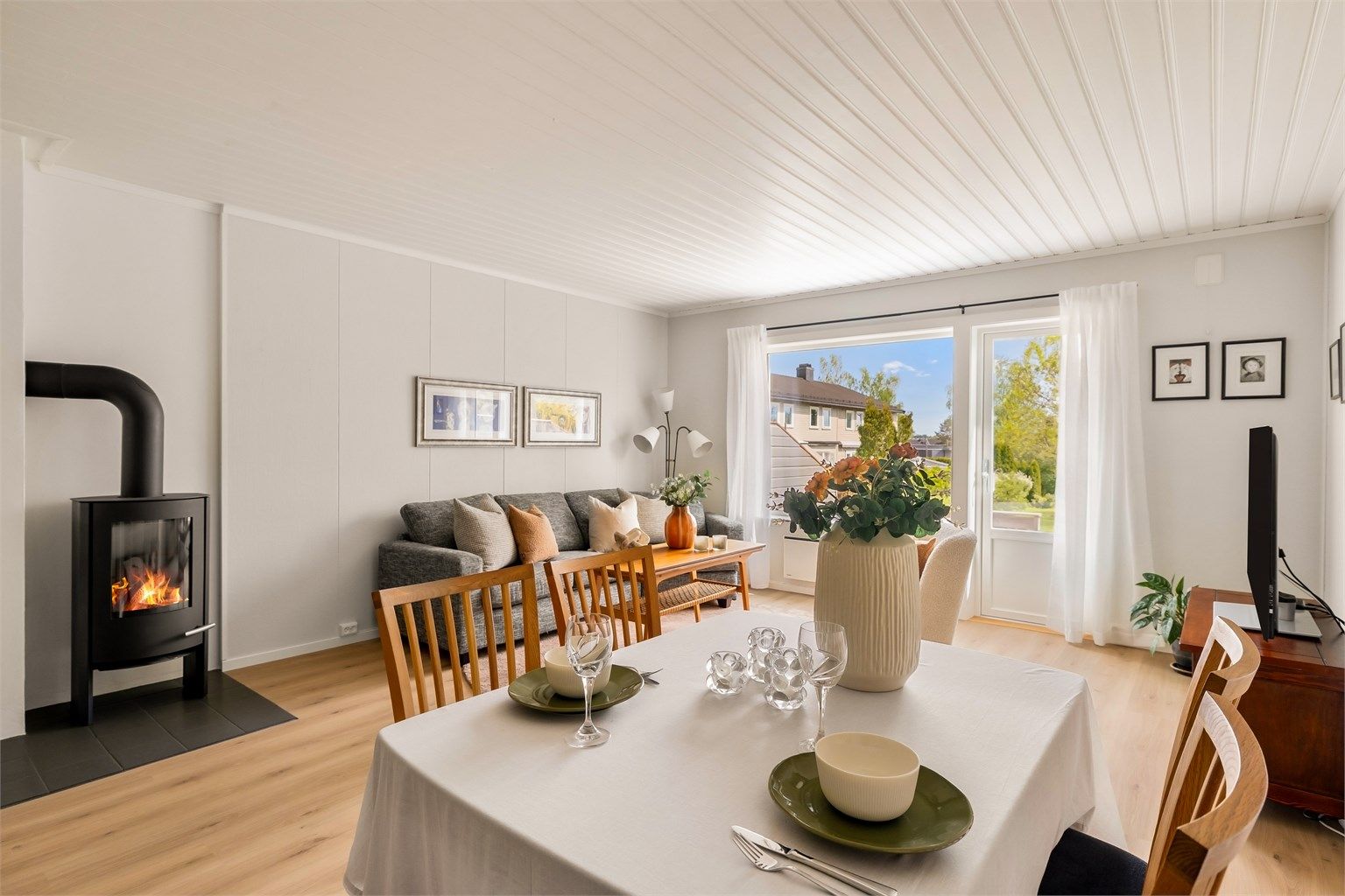 Velkommen til bords. Stuen har rikelig med plass til både sofagruppe og spisebord.