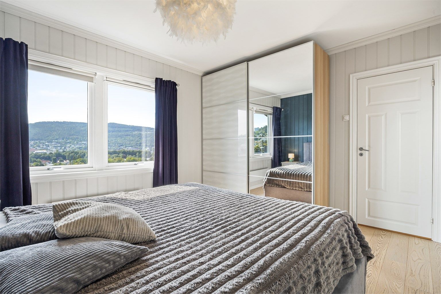 Romslig skyvedørsgarderobe med speilfront gir rikelig med oppbevaringsplass.