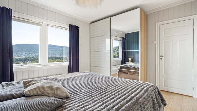 Romslig skyvedørsgarderobe med speilfront gir rikelig med oppbevaringsplass.