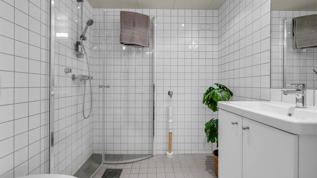 Delikat flislagt bad fra byggeår med oppgradert med nye dusjdører fra 2026. Tilrettelagt opplegg for vaskemaskin.