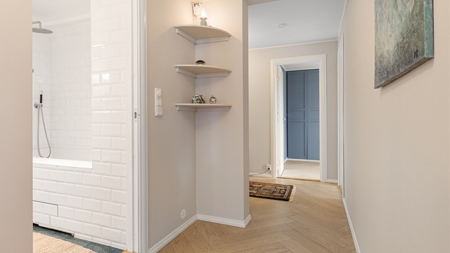 Små detaljer som de innebygde hjørnehyllene bidrar til leilighetens sjarme og funksjonalitet.