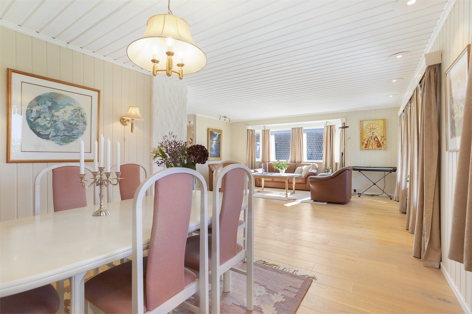 Gjennomgående eikeparkett og panelbord i himling med downlights.