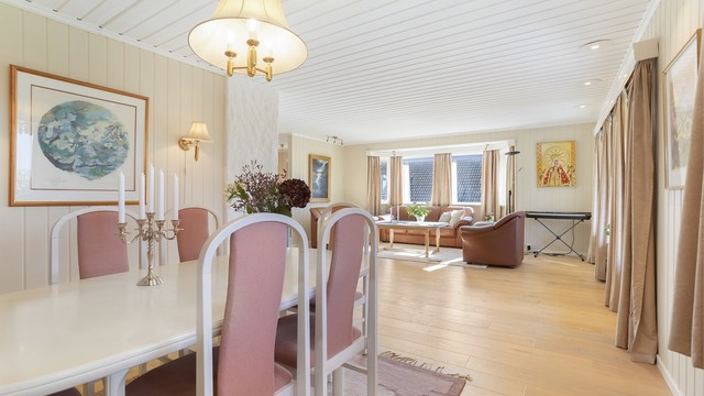Gjennomgående eikeparkett og panelbord i himling med downlights.