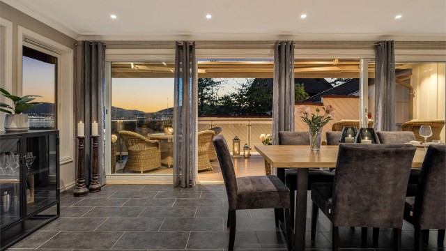 Spisestuen har flislagt gulv med varmekabler og utgang til terrasse gjennom en skyvedør i glass.