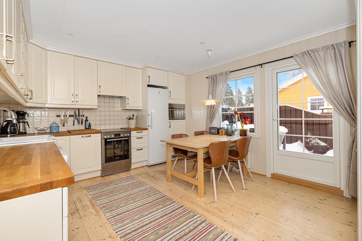 Lyst og romslig kjøkken med plass til spisegruppe. Det medfølger oppvaskmaskin, komfyr og kjøleskap.