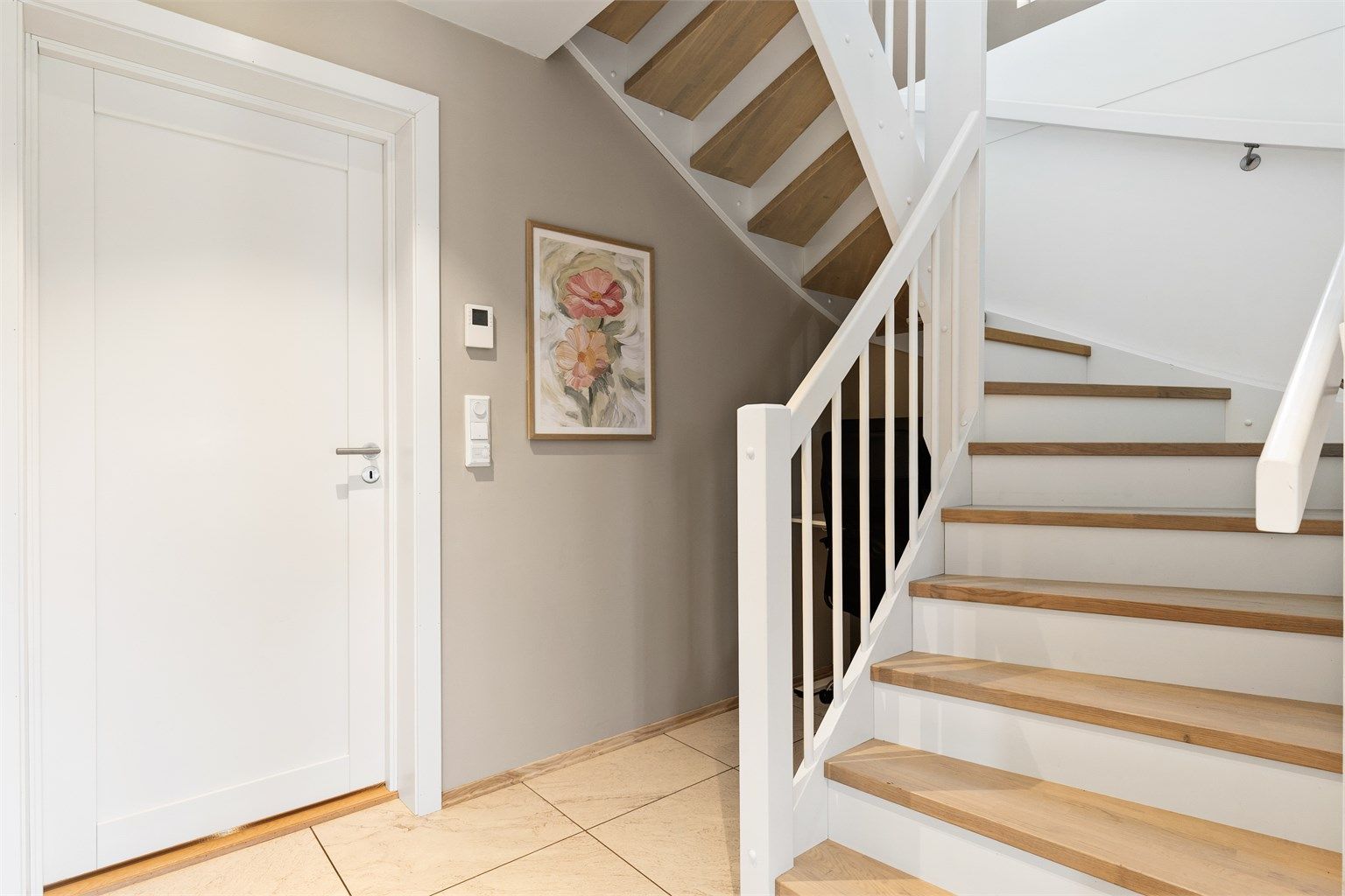 Innvendig tretrapp som forbinder de to etasjene. Det er gulvvarme i entréen.