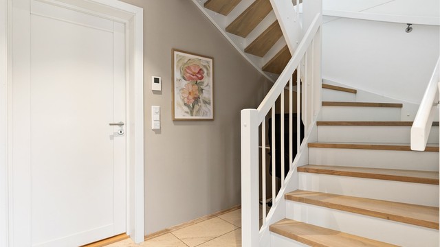 Innvendig tretrapp som forbinder de to etasjene. Det er gulvvarme i entréen.