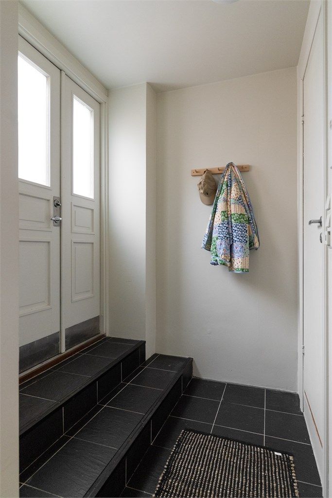Entreen har flislagte gulvflater og plass til jakker og sko.