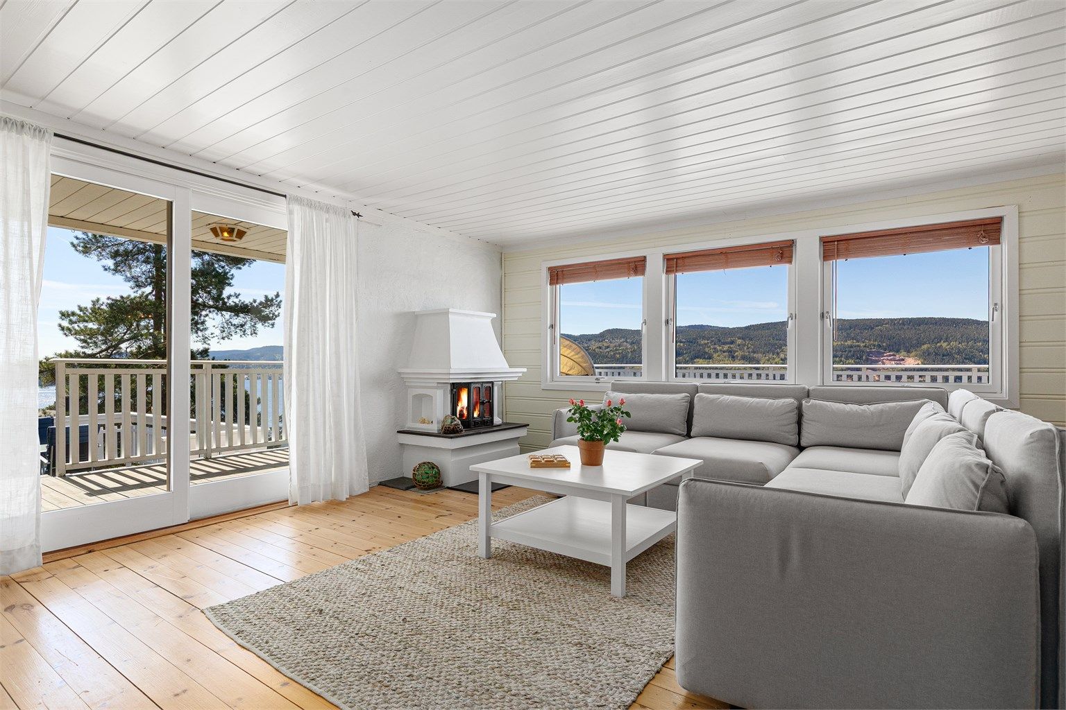 Hytta er malt opp i lyse og sommerlige farger. Fra stuen er det utgang til terrasse