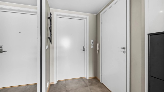 Velkommen inn i en lys entré med flislagt gulv og behagelig vannbåren gulvvarme.