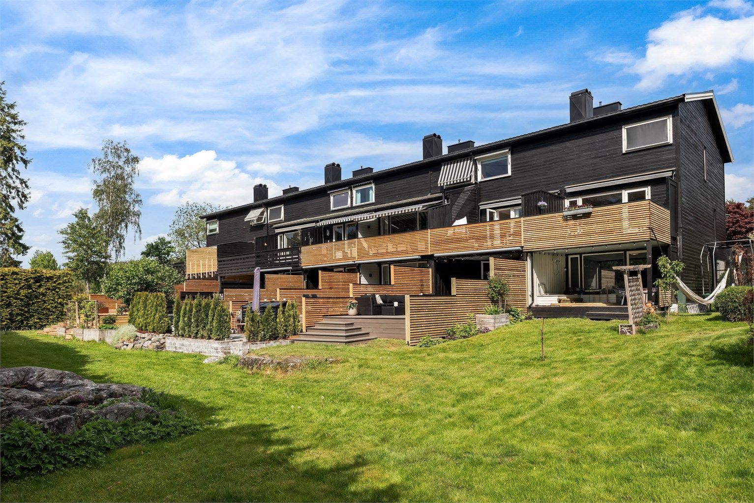 Hagen rundt boligen er en del av fellesarealet til velforeningen, men blir en naturlig forlengende av uteplass til boligen. 