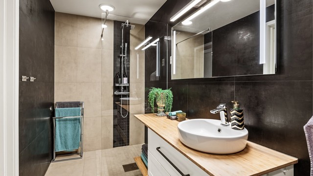 Hovedbadet fra 2018, har flislagte overflater, gulvvarme og dusj med glassvegg.