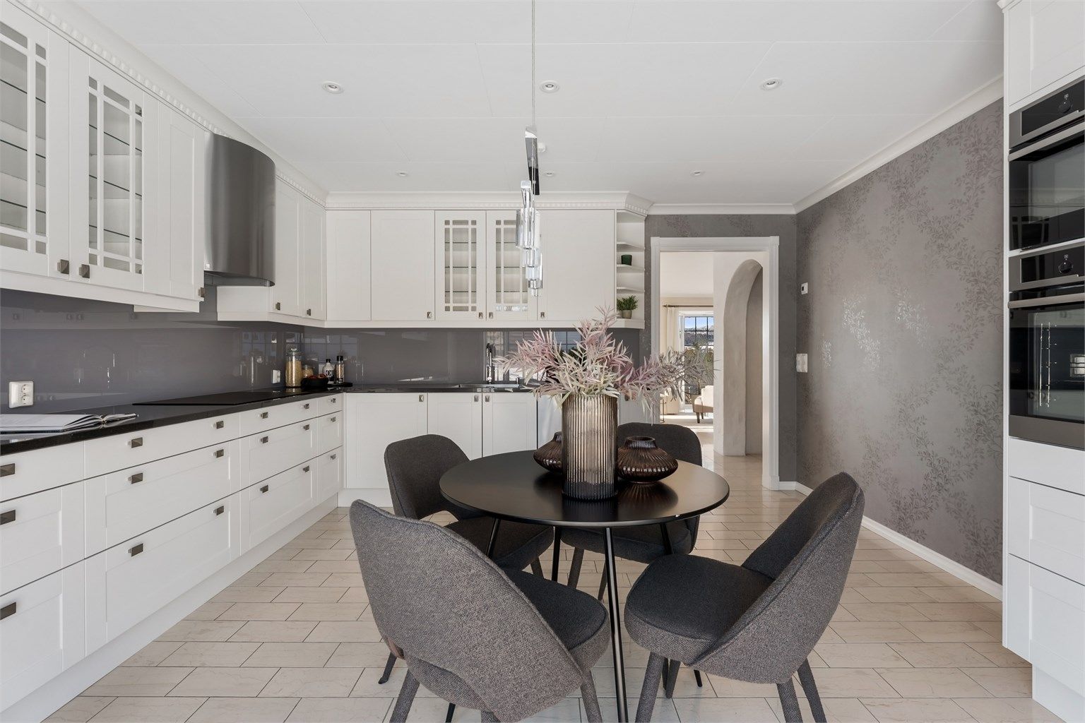 Kjøkkenet har flislagt gulv med gulvvarme og nedsenket himling med downlights.