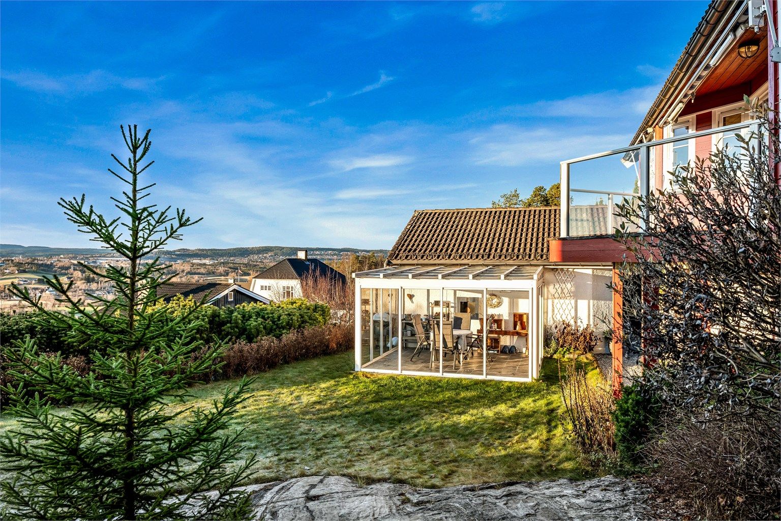 Den innglassede uteplassen på 13 m² ved garasjen forlenger utendørssesongen.