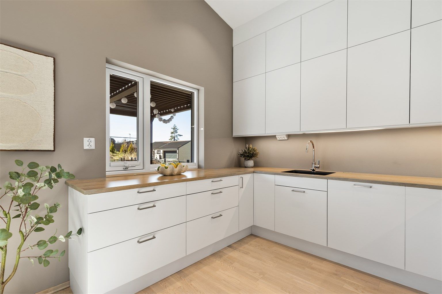 Fra kjøkkenvinduet har du direkte utsyn og utgang til den store terrassen.