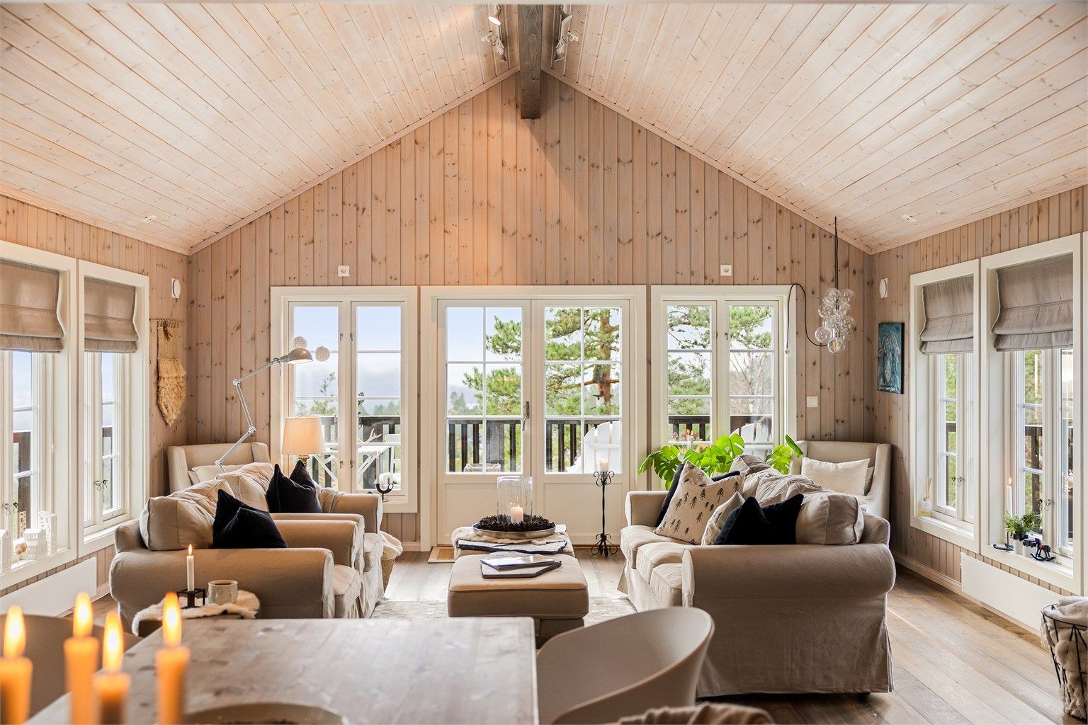 Stuen er delikat innredet med møbler i nøytrale naturfarger. I hjørnene mot gavlveggen er det en lesekrok på begge sider.