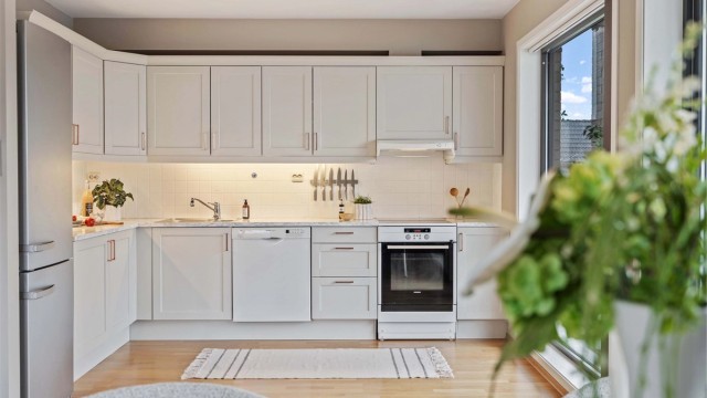Et funksjonelt og velholdt kjøkken med profilerte fronter og rikelig med skap- og benkeplass.