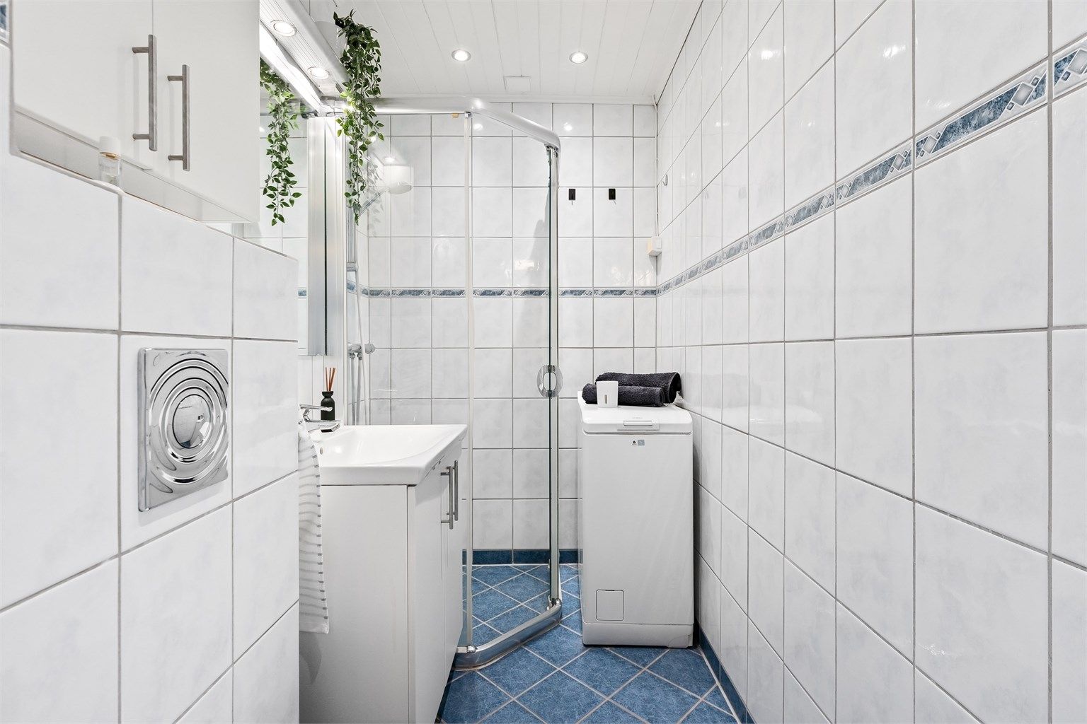 Baderommet fremstår moderne og funksjonelt, med flislagt gulv med gulvvarme og flislagte vegger