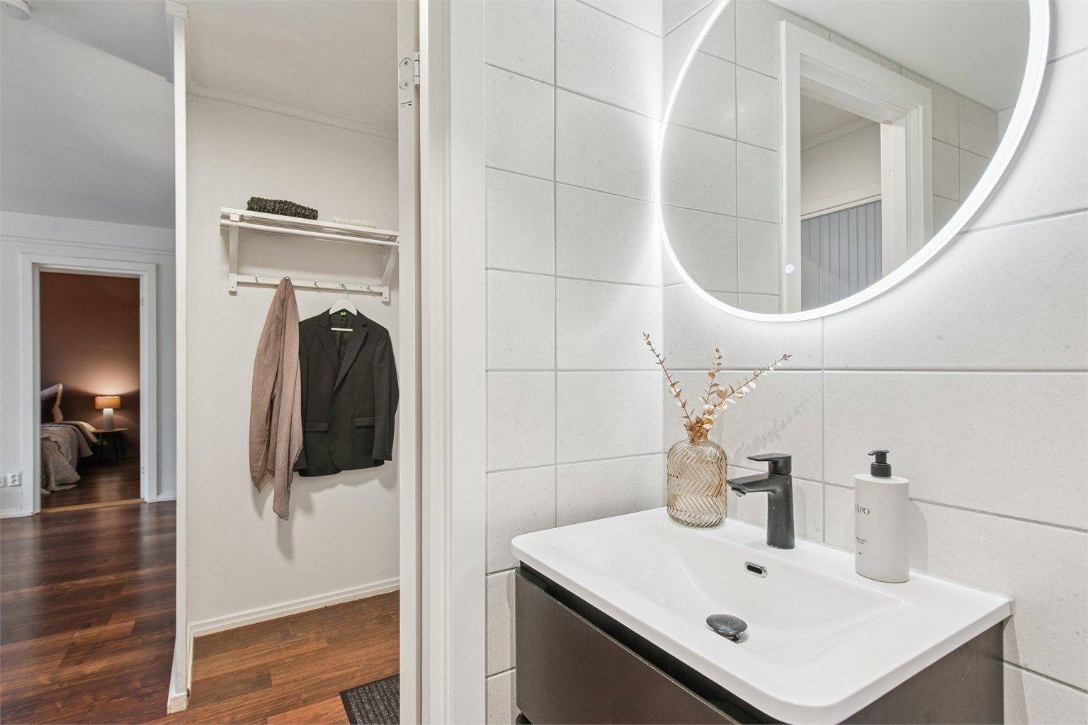 Her er det flislagte overflater, pen innredning, gulvvarme, dusjhjørne og vegghengt toalett, samt opplegg for vaskemaskin.