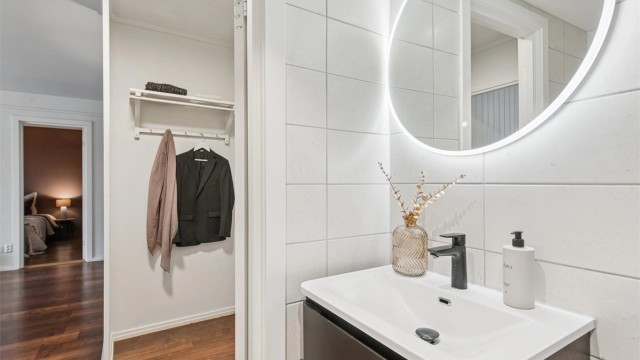 Her er det flislagte overflater, pen innredning, gulvvarme, dusjhjørne og vegghengt toalett, samt opplegg for vaskemaskin.