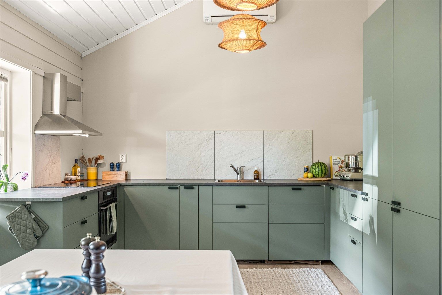Innbydende kjøkken i moderne farger, med slette fronter og integrerte hvitevarer.