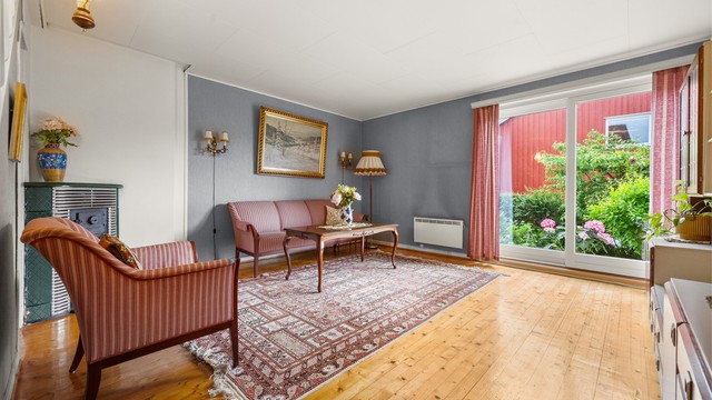 En eldre original vedkamin i stuen gir mulighet for ekstra oppvarming og en hyggelig atmosfære.