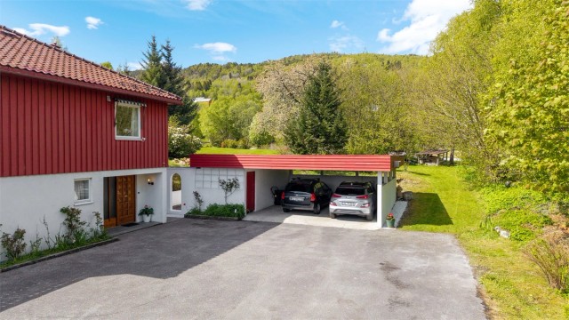 Carporten har et overbygd areal på ca. 33 m² og er bygget i murkonstruksjoner med tak i tre.