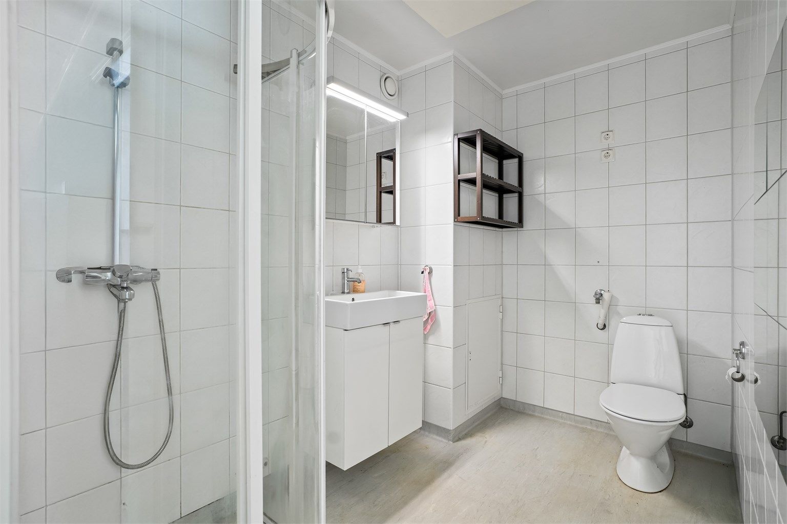 Badet er fra byggeår og har gulv belagt med gulvbelegg med gulvvarme samt flislagte vegger. Himlingen har malt overflate
