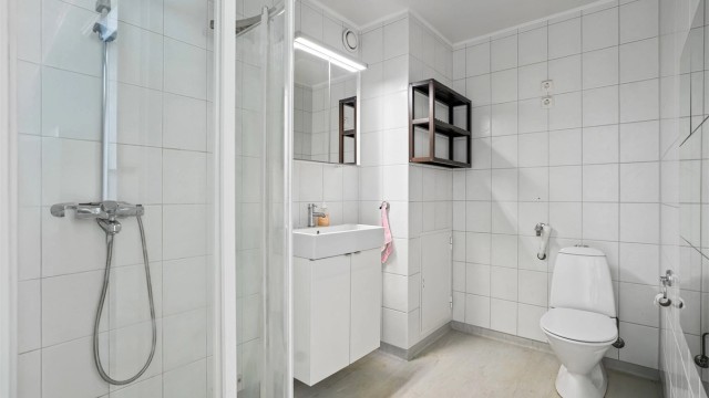 Badet er fra byggeår og har gulv belagt med gulvbelegg med gulvvarme samt flislagte vegger. Himlingen har malt overflate